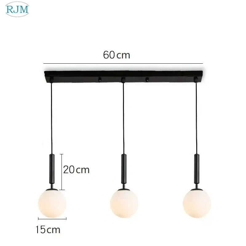 Black modern pendant light with three frosted glass ball led shades on a brass and black decorbites glass ball frame for dining room