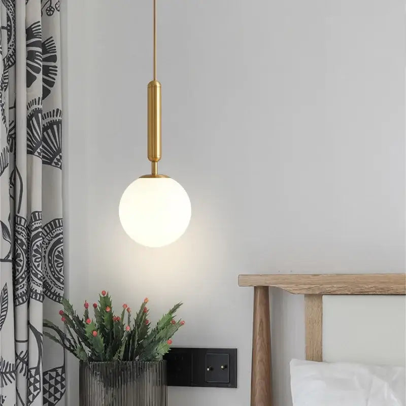 Modern brass and black glass ball pendant light with gold-toned fixture and frosted glass globe for dining room decorbites glass ball pendant
