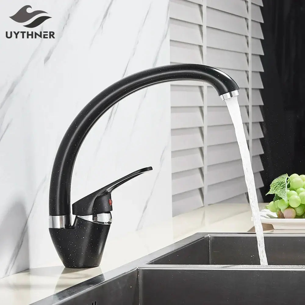 Modern brass black kitchen sink faucet with curved swivel spout featuring black speckled uythner design and chrome accents