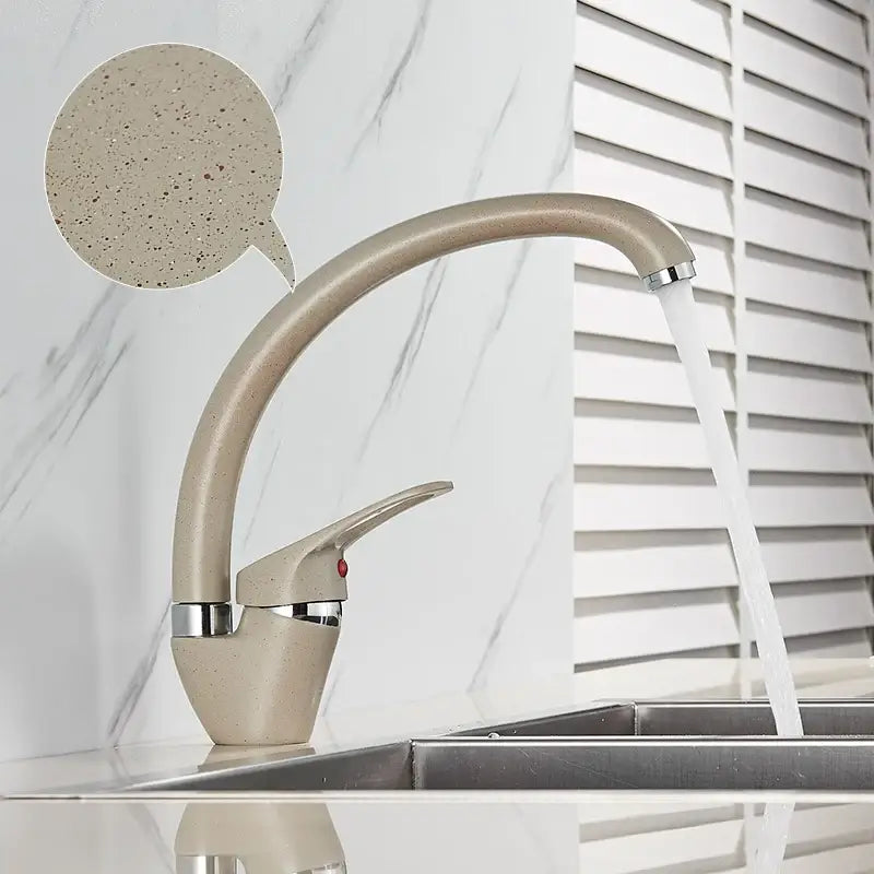Modern brass black kitchen sink faucet with a beige speckled curved spout and chrome decorbites brass black accents