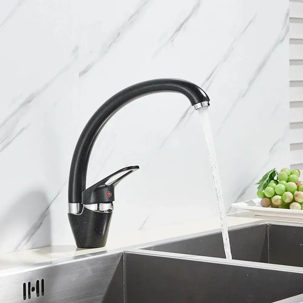 Modern brass black kitchen sink faucet with black matte finish chrome accents and curved swivel spout with flowing water