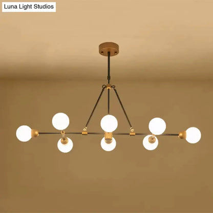 Modern brass finish island light with orb shade and six frosted glass bulbs for dining room lighting