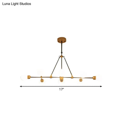 A modern brass finish dining room chandelier by Luna Light Studios with five orb glass shades and black metal accents