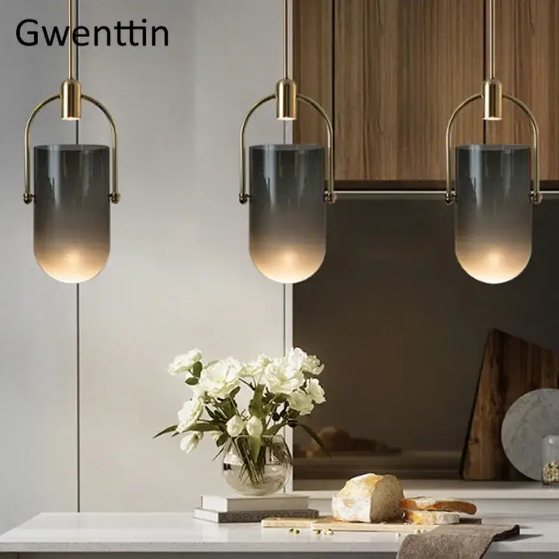Three modern pendant lamps with brass bucket glass frames and gray to clear shades for dining room decorbites bucket glass