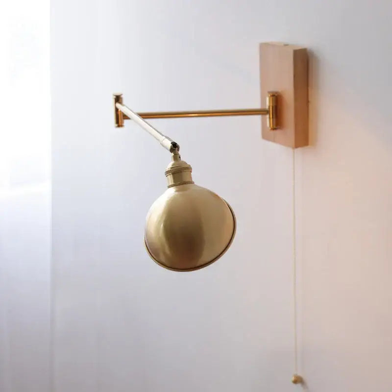 Modern brass canopy led wall light with adjustable brass finish, spherical shade, and wooden mounting plate decorbites canopy led