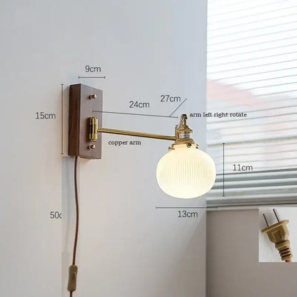 Vintage-style modern brass canopy led wall light with brass copper arm and ribbed off-white globe on dark wood plate