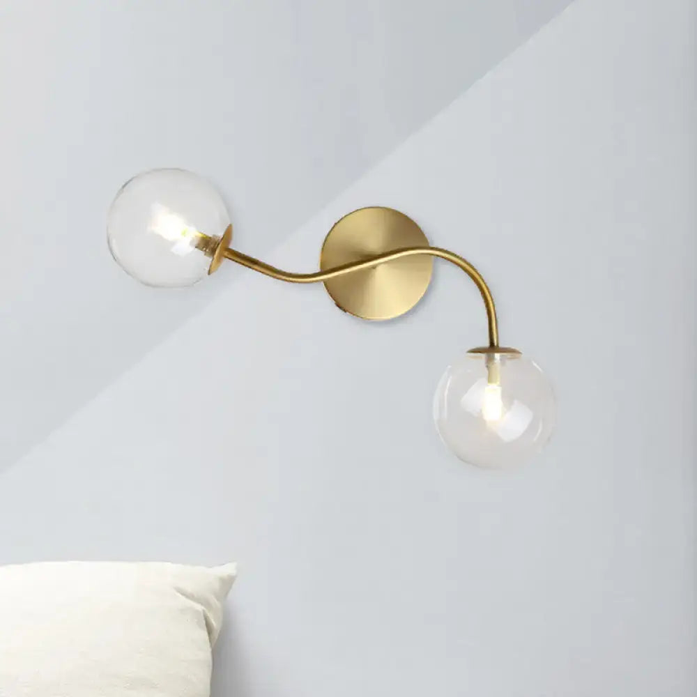 Modern brass wall lamp with clear tan glass globe shades and bulb base designed for stairway lighting