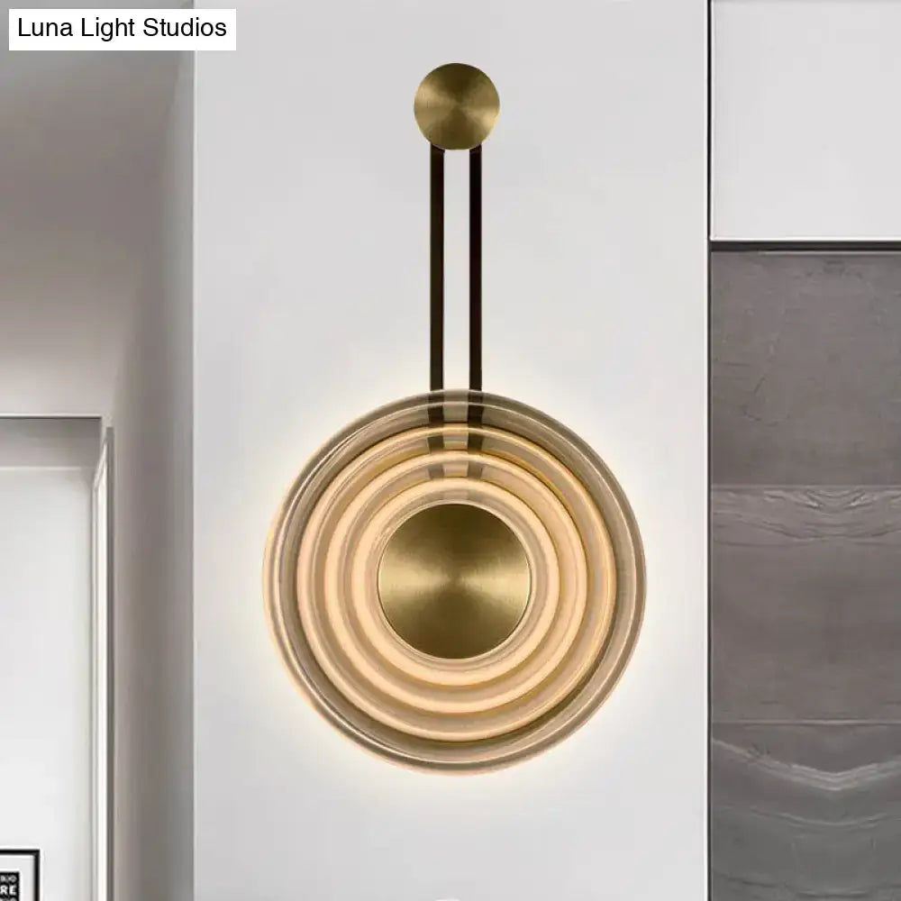 Modern brass wall lamp with concentric circular rings and sleek minimalist design highlighting fixture height for living room