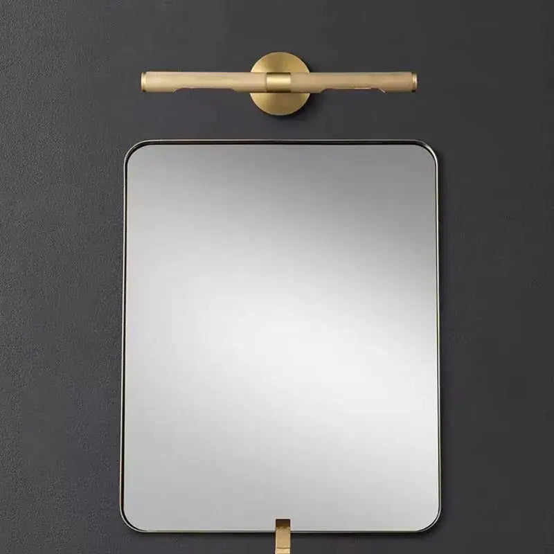 Modern brass copper mirror with sleek gold-toned metal frame and matching wall lamp for bedroom bathroom decorbites brass copper