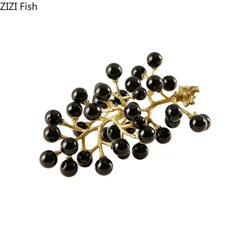 Gold-toned brooch with glossy black beads on branching stems resembling modern brass crystal grape ornaments sculpture