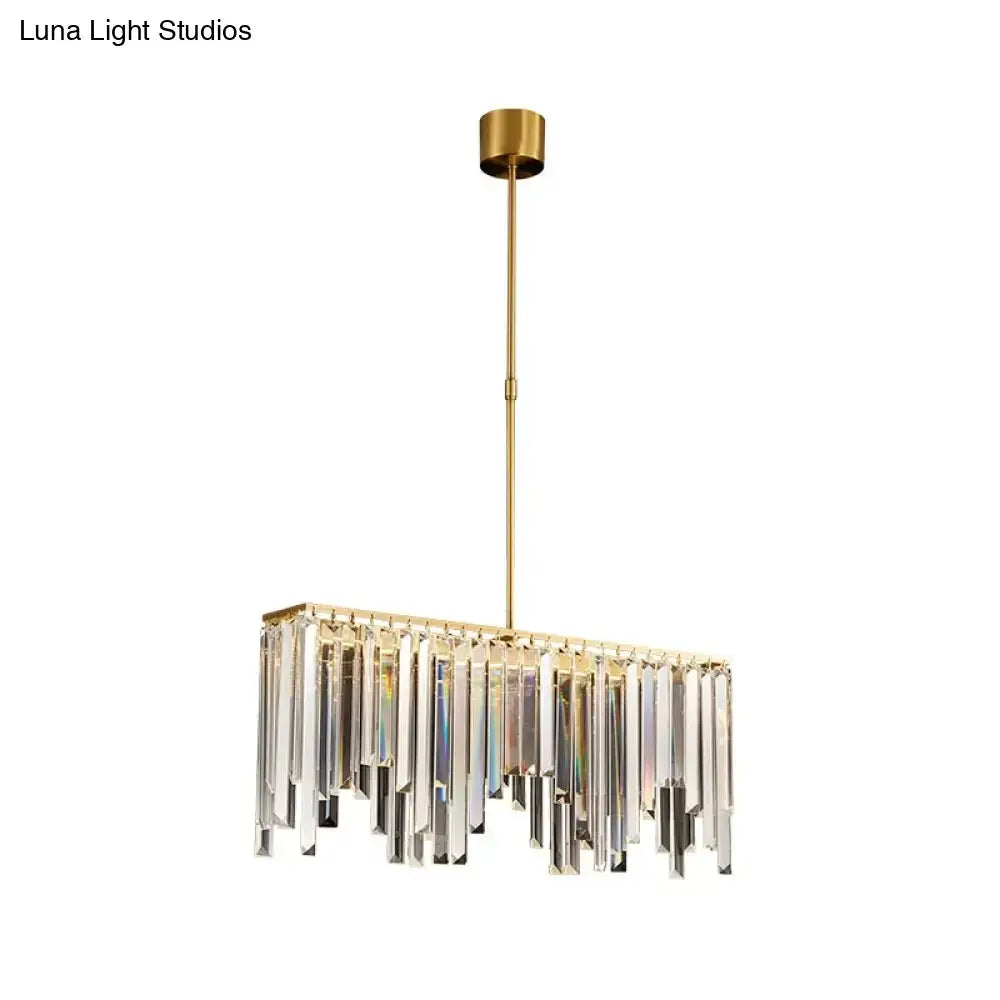 Modern brass crystal led island light with gold-toned rectangular frame and cascading clear crystal prisms for dining room