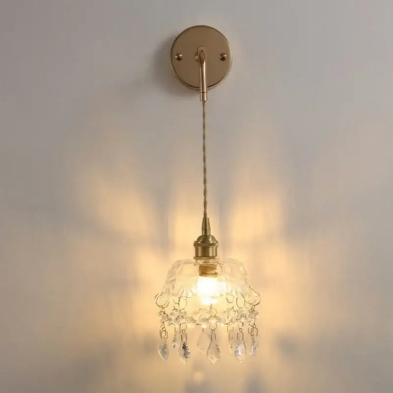 Modern brass crystal wall lamp featuring a delicate brass sconce with decorbites clear glass chandelier shade and teardrop crystals