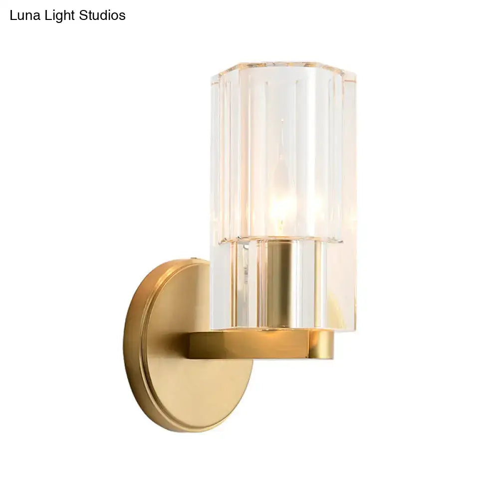 Modern brass crystal wall mount lamp with brushed gold metal base and clear faceted glass for warm bedroom lighting