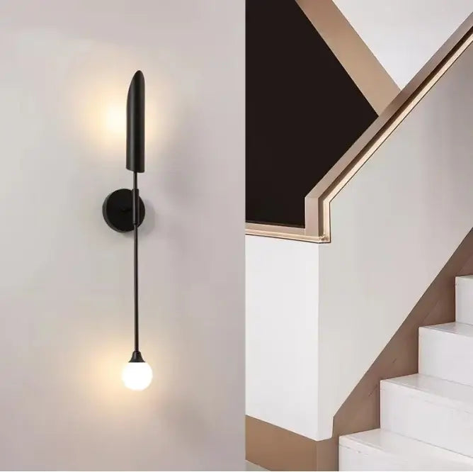 Modern brass cylindrical wall light with black minimalist stem and spherical bulb for golden luxury wall decorbites wall light