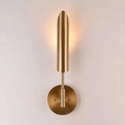 Modern brass cylindrical wall light with a sleek elongated shade and circular base for decorbites golden luxury decor