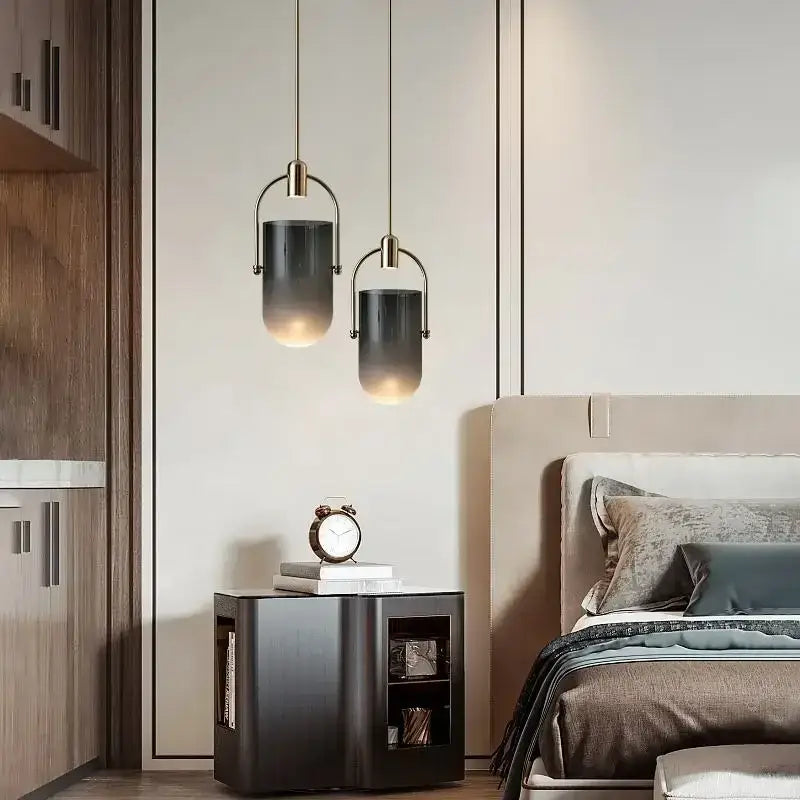 Two pendant lights with dark gray glass shades and brass frames in a modern decorbites bucket chandelier design