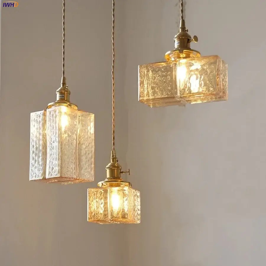 Three brass-finished pendant lamps with textured cube amber glass shades by decorbites for dining room lighting