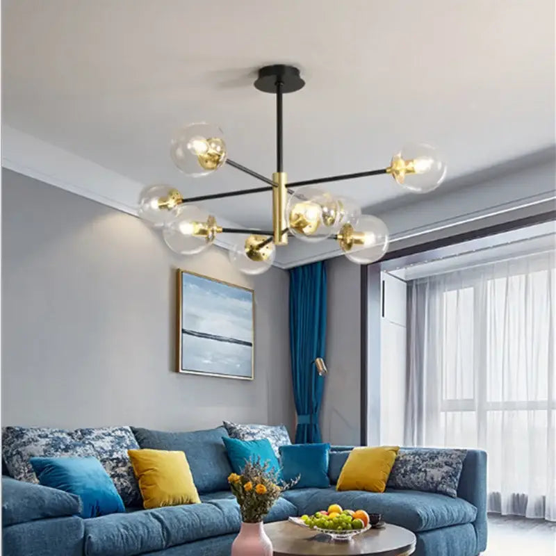 Modern brass decorbites glass ball led chandelier with black rod and gold accents featuring clear glass globe bulbs