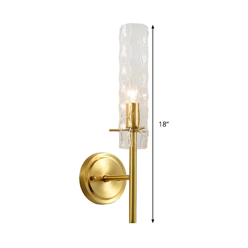 A sleek 18-inch modern brass wall light with dimpled blown glass cylinder and frosted textured shade for bedrooms