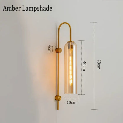 Modern brass e27 glass wall light with gold-toned frame amber clear glass lampshade and exposed filament bulb for bedroom use