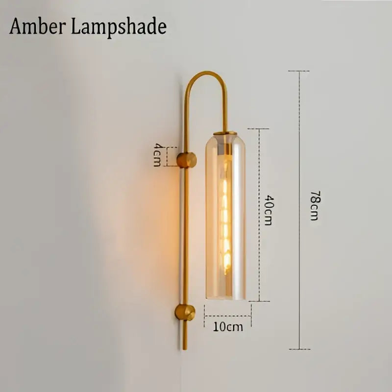 Modern brass e27 glass wall light with gold-toned frame amber clear glass lampshade and exposed filament bulb for bedroom use