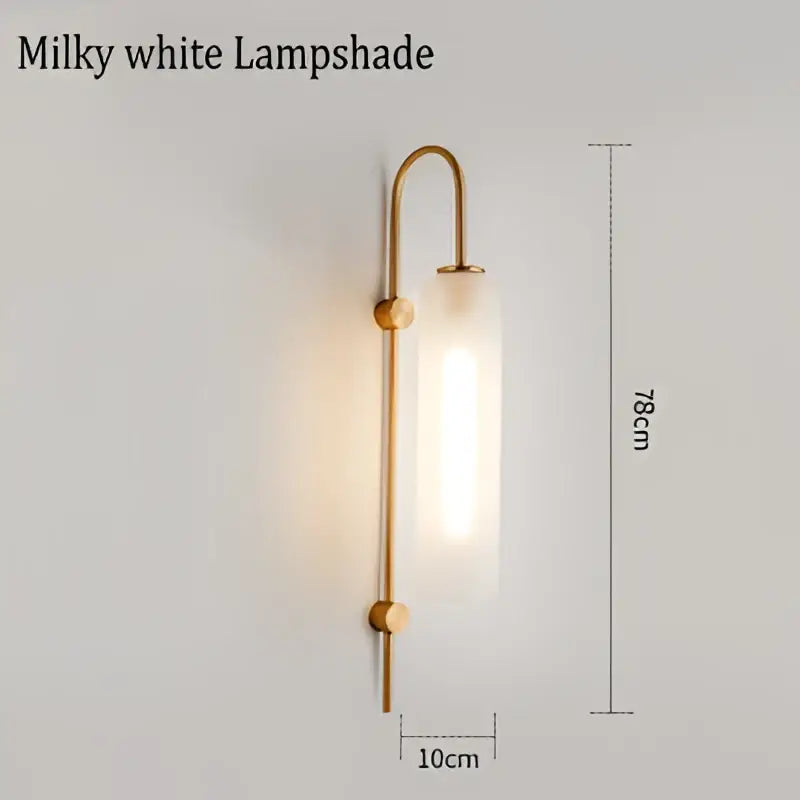 Modern brass e27 glass wall light with milky white glass lampshade and wooden accents mounted on brass sconce