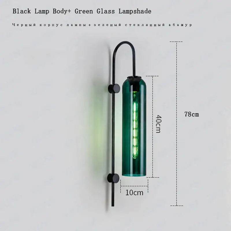 A sleek black metal modern brass e27 glass wall light with a tall green glass shade and illuminated led filament bulb
