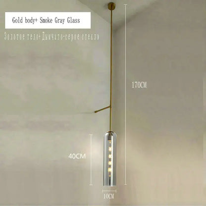 A modern brass e27 glass wall light with a gold-toned frame and smoked gray cylinder housing for bedroom use