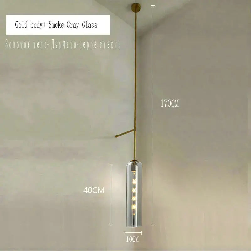 A modern brass e27 glass wall light with a gold-toned frame and smoked gray cylinder housing for bedroom use