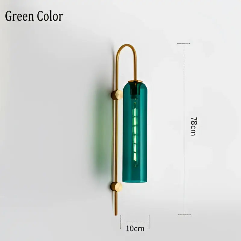 Modern brass e27 glass wall light featuring a teal glass cylinder with a brass-finished metal frame for bedroom use