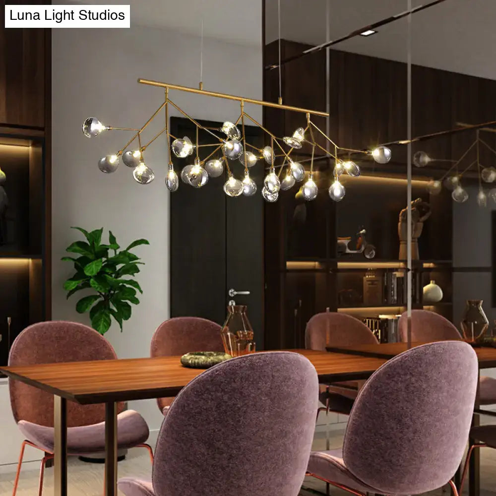 Gold-toned decorbites™ island light with brass finish and clear glass globes compatible with 220v-240v 110v-120v