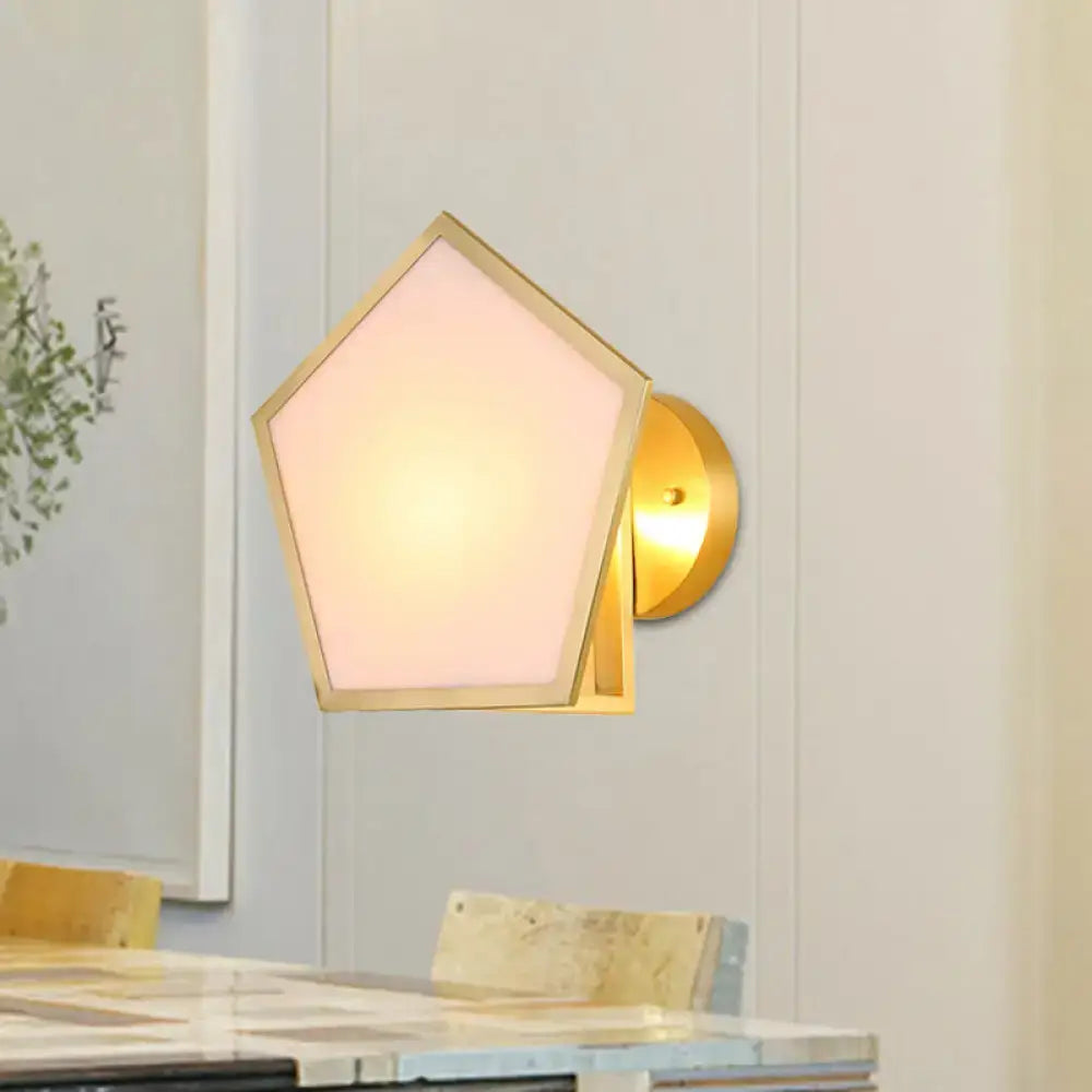 Modern brass finish pentagon wall lamp with gold-toned metal wall sconce and soft pink frosted glass shade for bedroom