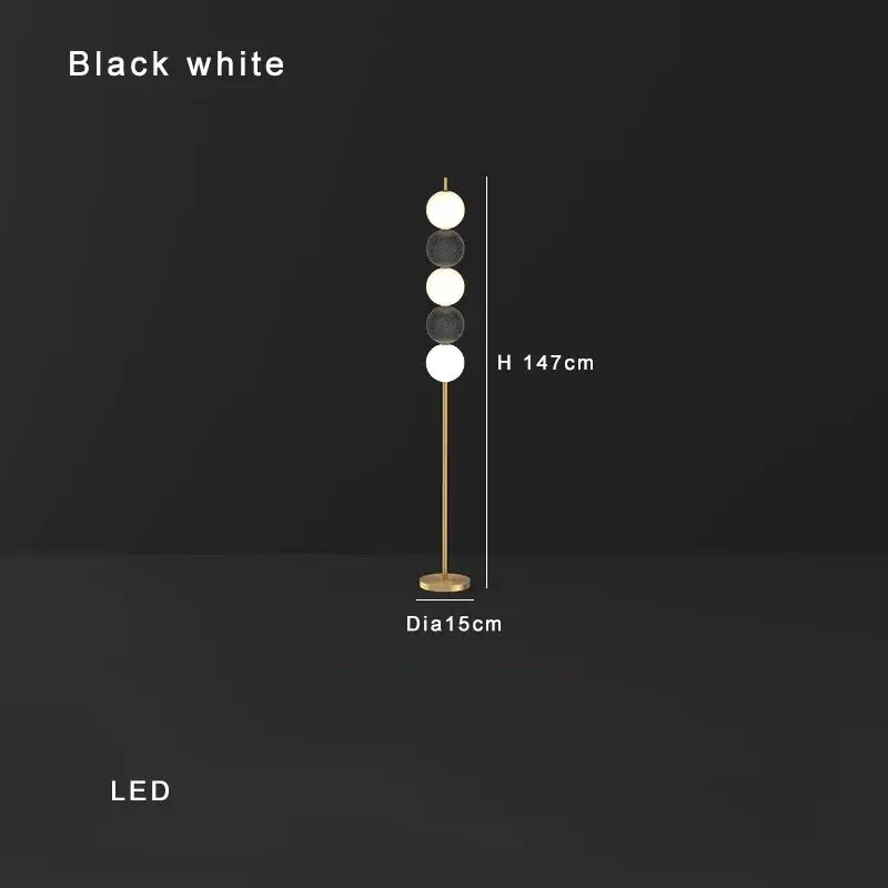 Modern brass floor lamp with four black and white led spheres on a slender pole for stylish living room decorbites decor
