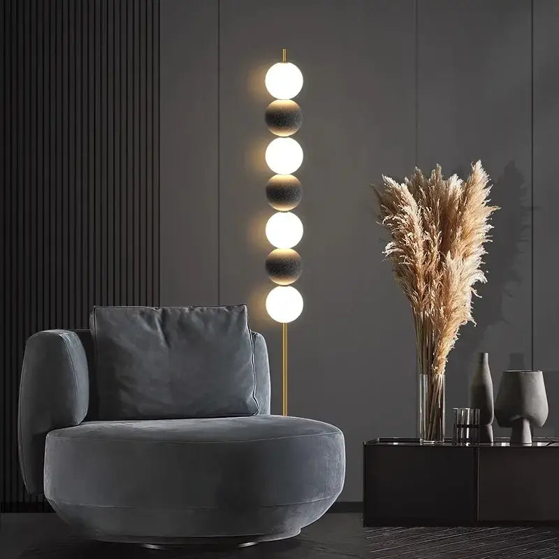 Modern brass floor lamp with five glowing spherical bulbs on a slender gold-toned stand for living room decorbites decor