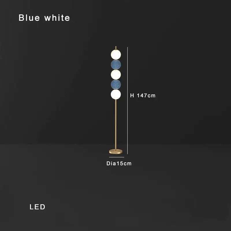 Modern brass floor lamp with six spherical white and blue shades on a slender gold-toned brass floor lamp stand for decorbites decor