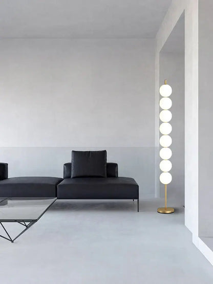 Modern brass floor lamp with six white glass spheres on a gold-finished metal base for living room decorbites brass floor use