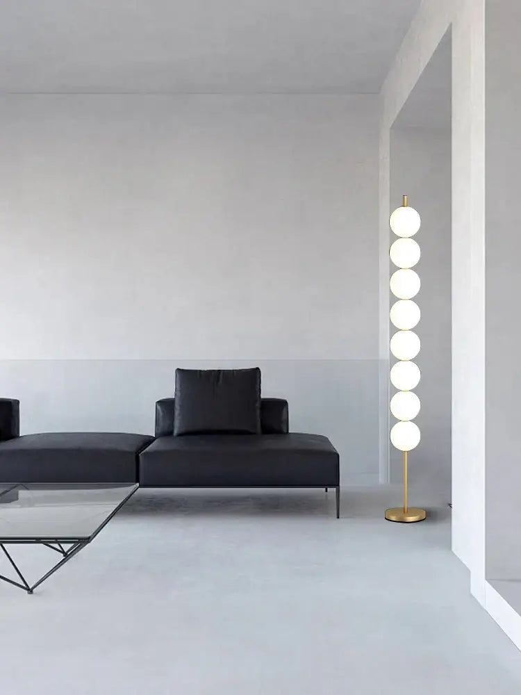 Modern brass floor lamp with six white glass spheres on a gold-finished metal base for living room decorbites brass floor use