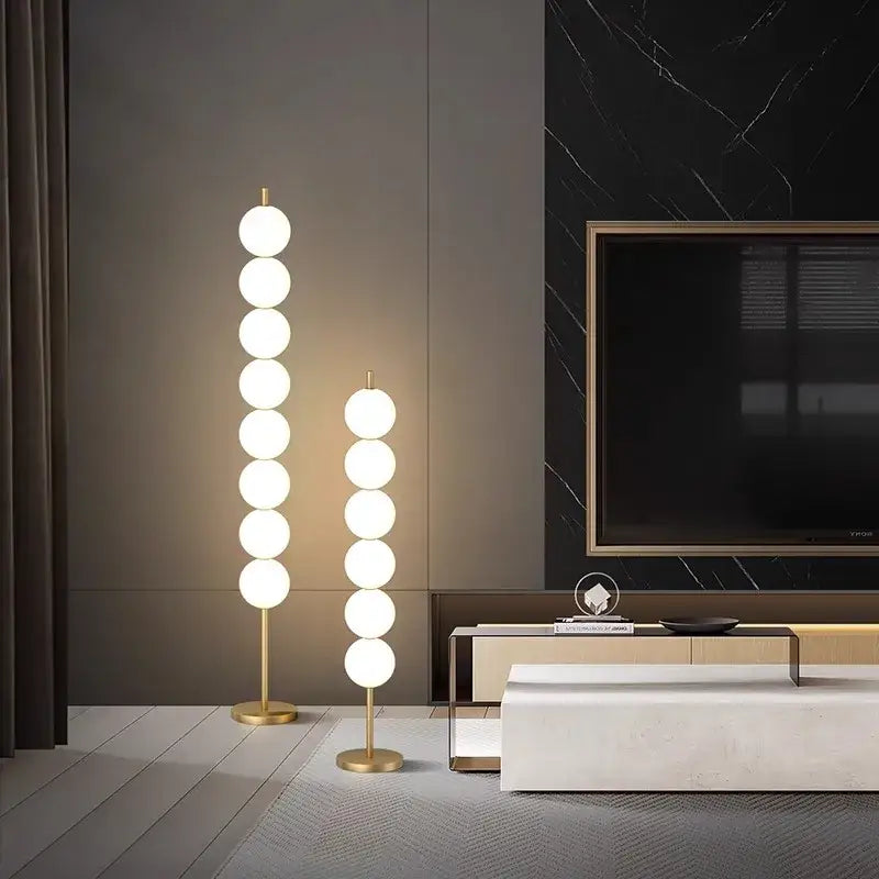 Modern brass floor lamp with slender gold stand and seven glowing white spheres for living room decorbites brass floor lamp