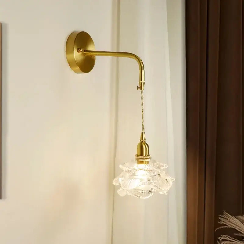 Modern brass flower led wall sconce with a gold-toned curved arm and ornate clear crystal glass shade for bedroom decorbites led wall lighting