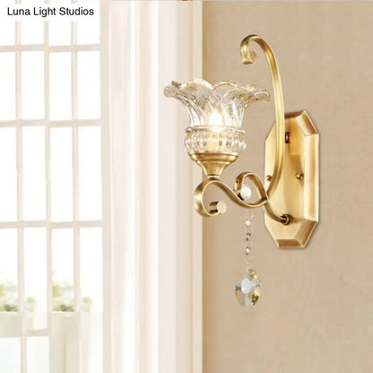 Modern brass flower sconce wall lamp with gold-toned metal, faceted glass shade, and crystal pendant light fixture
