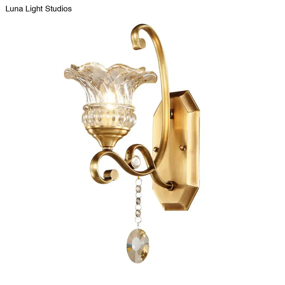 Modern brass flower sconce wall lamp with gold-toned curved arm and clear fluted glass light fixture for bedroom