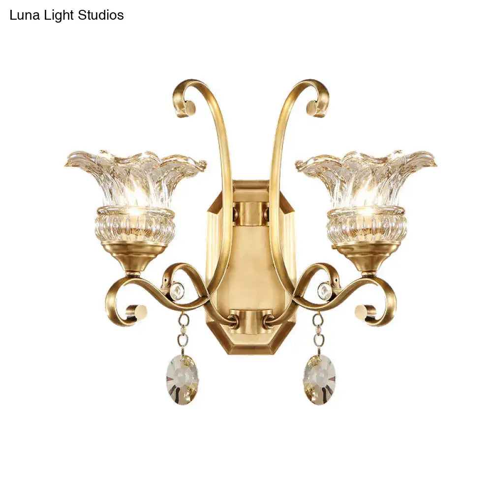 Gold-finished modern brass flower sconce wall lamp with two crystal shades and dangling faceted teardrop crystals light fixture