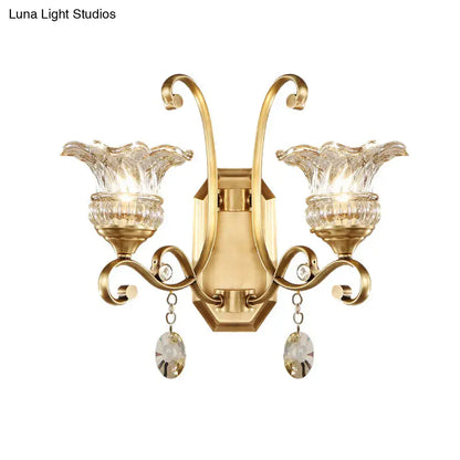 Gold-finished modern brass flower sconce wall lamp with two crystal shades and dangling faceted teardrop crystals light fixture