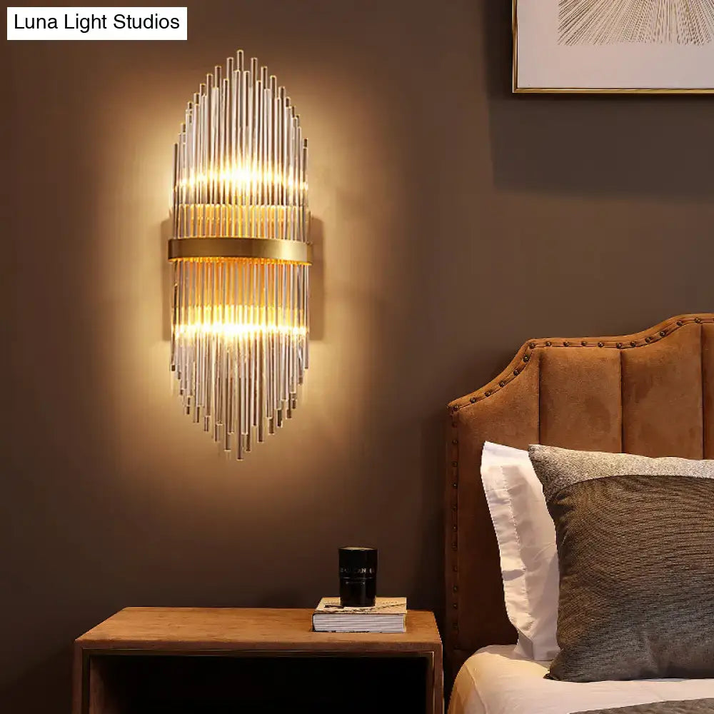 Modern brass wall sconce with fluted glass shade and direct wired electric design emitting warm bedroom light