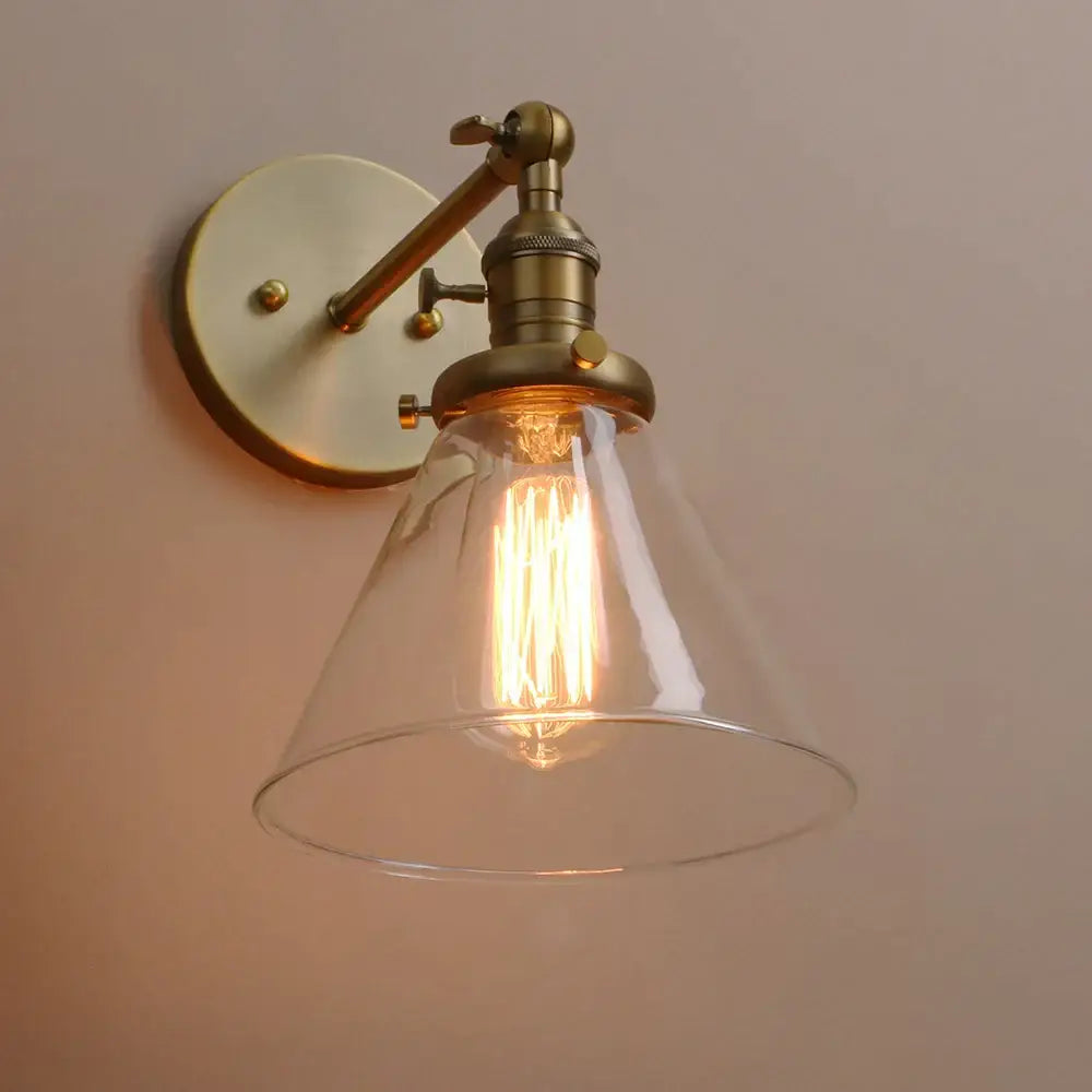 Modern brass funnel glass wall lamp with adjustable brass finish and clear conical glass shade for bedroom lighting