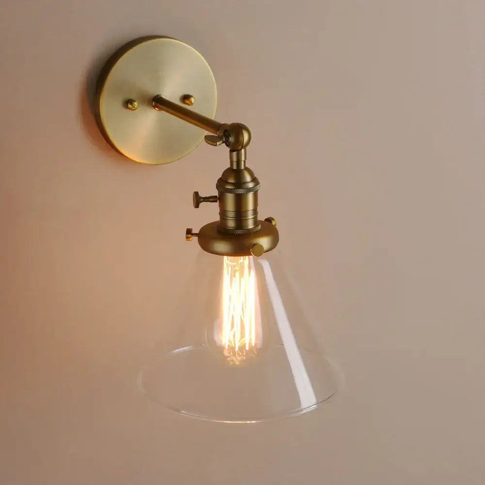 Modern brass funnel glass wall lamp with clear conical shade and exposed filament bulb for bedroom lighting decorbites funnel glass wall