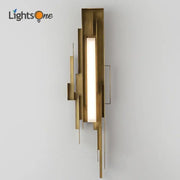 Modern brass geometric elegant wall lamp featuring a layered design and central illuminated rectangular panel for living room