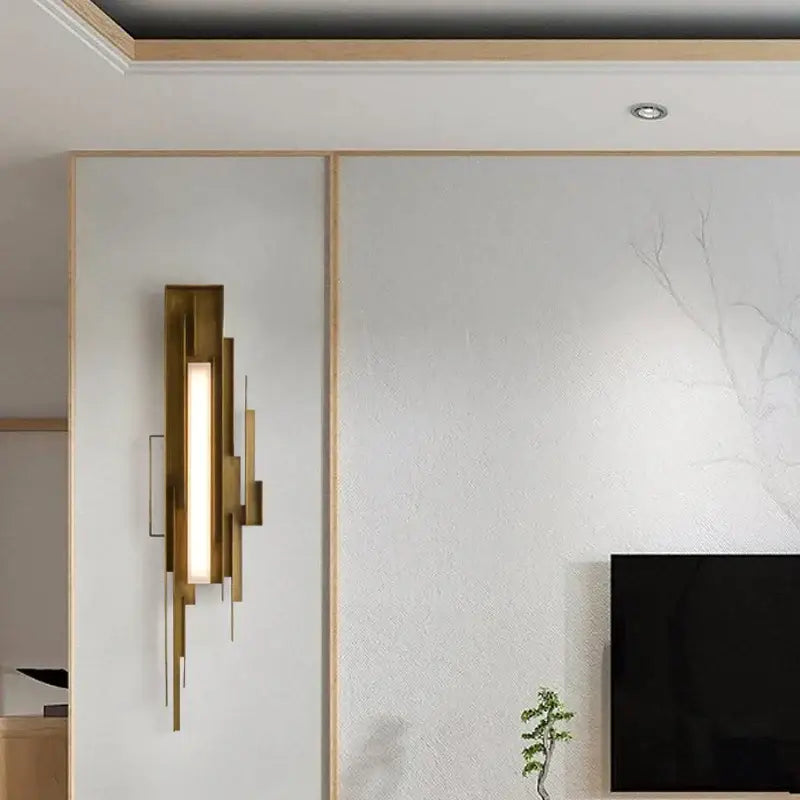 Modern brass elegant wall lamp with gold-toned layered geometric design and vertical illuminated panel for living room use