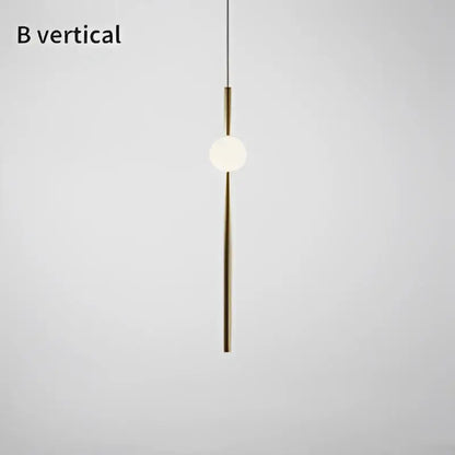 Modern brass geometric glass pendant light featuring a sleek vertical rod and glowing bulb for dining room use