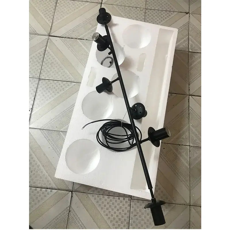 Black metal adjustable spotlight fixture with multiple heads and coiled power cord for modern brass glass ball chandelier decorbites brass glass
